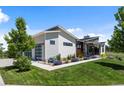 Modern home with a unique roofline, featuring a tandem 3-car garage and manicured landscaping at 10205 Inspiration Dr, Parker, CO 80138