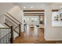 Open-concept living room featuring a beautiful stone fireplace, wood beams and hardwood floors at 2966 Casalon Cir, Superior, CO 80027