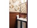 Stylish powder room with striking horse-themed wallpaper, dark wainscoting, and a vanity with a gold faucet at 940 N Ogden, Denver, CO 80218
