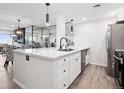 Modern kitchen with stainless steel appliances, white cabinetry, and a large island with a sink at 800 N Pearl St # 1203, Denver, CO 80203