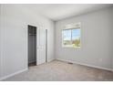 Bright, carpeted bedroom with a closet and a large window offering natural light at 10065 Quari Ct, Commerce City, CO 80022