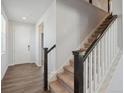 Bright entryway with hardwood floors and a staircase leading to the upper level at 10065 Quari Ct, Commerce City, CO 80022