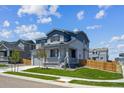 Inviting two-story home featuring a manicured lawn and cozy front porch at 10065 Quari Ct, Commerce City, CO 80022