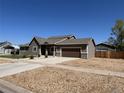 Charming single-Gathering home featuring a well-manicured lawn, concrete driveway, and backyard shop building at 504 Elizabeth Ave, Platteville, CO 80651