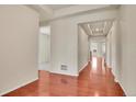 Bright hallway with gleaming hardwood floors leading to other rooms at 16076 Columbine Pl, Thornton, CO 80602