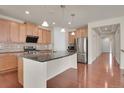 Spacious kitchen featuring stainless steel appliances, a central island, and modern finishes at 16076 Columbine Pl, Thornton, CO 80602