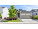 Attractive single-Gathering home with a two-car garage, stone details, and manicured front lawn at 21893 E Tufts Cir, Aurora, CO 80015