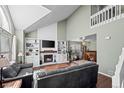 Bright living room with vaulted ceilings, fireplace, and built-in shelving units at 10407 Strasburg Way, Parker, CO 80134