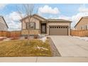 House exterior view, featuring a tan house and landscaping at 27957 E 9Th Dr, Aurora, CO 80018