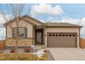 Beige exterior house with brown garage door and landscaping at 27957 E 9Th Dr, Aurora, CO 80018