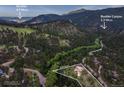 Breathtaking aerial view of a mountain home on a 0.9 acre lot, surrounded by lush forest and scenic roads at 207 Kelly E Rd, Boulder, CO 80302