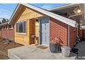 Welcoming front porch showcasing brick and wood siding and a well manicured outdoor space at 2415 E Maplewood Ave, Centennial, CO 80121