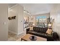 Inviting living room with a leather couch and lots of natural light, leading into the kitchen and work space at 5677 S Park Pl # C208, Englewood, CO 80111