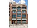 A brick multi-story building with green-trimmed windows, and small balconies outside some windows at 2245 Blake St # C, Denver, CO 80205