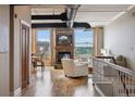 An open-concept living room with hardwood floors, a stone fireplace, and large windows with views of the city at 2245 Blake St # C, Denver, CO 80205