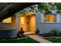 Inviting front porch with decorative trim and well-manicured landscaping and walkway at dusk at 3001 S Josephine St, Denver, CO 80210