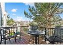 Outdoor deck with metal patio furniture surrounded by trees with a view of the neighborhood at 2796 Newport Cir, Castle Rock, CO 80104