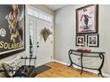 Bright entryway with wood floors, decorative art, and a glass table at 2796 Newport Cir, Castle Rock, CO 80104
