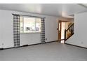 Bright living room with large window, neutral carpet, and entry view at 1040 Hemlock Way, Broomfield, CO 80020