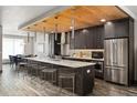 Modern kitchen boasts stainless steel appliances, a large island with seating, and a beautiful dining area at 47 Harrison, Denver, CO 80206