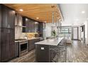 Modern kitchen boasts stainless steel appliances, a large island with seating, and stylish lighting at 47 Harrison, Denver, CO 80206