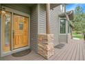 Welcoming front door with transom window, complemented by a covered porch and decorative brickwork at 31139 Tahoe Ct, Evergreen, CO 80439