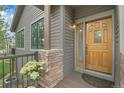 Charming front door with sidelight window and craftsman details, set on a covered porch at 31139 Tahoe Ct, Evergreen, CO 80439