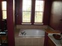 Bathroom featuring a soaking tub under two windows, next to a vanity with a wooden sink at 12317 W Gould Ave, Littleton, CO 80127