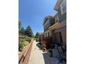 Two-story townhome featuring a patio, landscaping, and a sidewalk bordering the side of the unit at 12317 W Gould Ave, Littleton, CO 80127