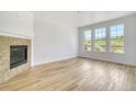 Bright living room features hardwood floors, modern fireplace, and three large windows offering natural light at 12317 W Gould Ave, Littleton, CO 80127