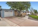 Home exterior featuring a driveway, garage, landscaped yard and a charming walkway to the front door at 6761 Harlan St, Arvada, CO 80003