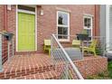Cozy front porch featuring brick steps and seating area with bright green chairs at 8851 E 33Rd Ave, Denver, CO 80238
