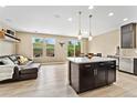 Bright living space with modern island and stainless appliances, seamlessly blending the kitchen and living areas at 15061 W 70Th Ave, Arvada, CO 80007