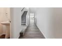 Bright entryway with a powder room, leading to the staircase with carpeted steps and wood-look flooring at 170 Lark Sparrow Way, Bennett, CO 80102