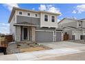 Modern two-story home with a neutral gray exterior, a two-car garage, and stone accents at 170 Lark Sparrow Way, Bennett, CO 80102