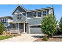 Charming two-story home with blue siding, gray accents, a well-maintained lawn and low maintenance landscaping at 26857 E Maple Ave, Aurora, CO 80018