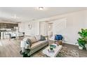 Open concept living room boasts sleek flooring, neutral walls, and a staircase leading to the upper level at 26857 E Maple Ave, Aurora, CO 80018