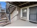 Exterior entrance to unit with wood stairs, gray paint and visible door to a second home at 8100 W Quincy Ave # A8, Littleton, CO 80123