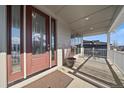 Inviting covered front porch with a cozy seating area and views at 4565 Colorado River Dr, Firestone, CO 80504