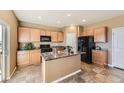 Spacious kitchen featuring an island, black appliances, and ample cabinetry at 4807 River Highlands Loop, Elizabeth, CO 80107