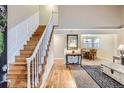 Bright foyer with hardwood floors, staircase, and open view to the formal dining room at 8985 W Quarto Pl, Littleton, CO 80128
