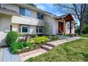 Charming home with colorful landscaping, a brick walkway, and a covered front porch at 5925 E Fair Ave, Centennial, CO 80111