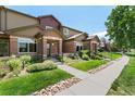Attractive townhouse exterior featuring lush landscaping and a well-manicured lawn at 6418 Silver Mesa Dr # C, Highlands Ranch, CO 80130
