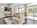 Bright living room with large windows, plush seating, and hardwood flooring at 18096 E 104Th Way, Commerce City, CO 80022