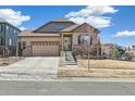 Lovely home with a neatly maintained lawn, complemented by stone accents and a welcoming front entrance on a sunny day at 7743 S Quantock Way, Aurora, CO 80016