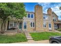 Charming townhouse featuring stone accents, lush lawn, and inviting front porch at 9615 W Chatfield Ave # C, Littleton, CO 80128