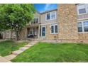Charming townhouse featuring stone accents, lush lawn, and inviting front porch at 9615 W Chatfield Ave # C, Littleton, CO 80128