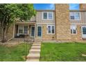 Charming townhouse featuring stone accents, lush lawn, and inviting front porch at 9615 W Chatfield Ave # C, Littleton, CO 80128