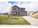 Inviting two-story home with a covered porch, red shutters, and a well-maintained front lawn at 2516 Mountain Sky Dr, Castle Rock, CO 80104