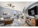 Bright living room featuring wood floors, a ceiling fan, and a modern fireplace at 2516 Mountain Sky Dr, Castle Rock, CO 80104